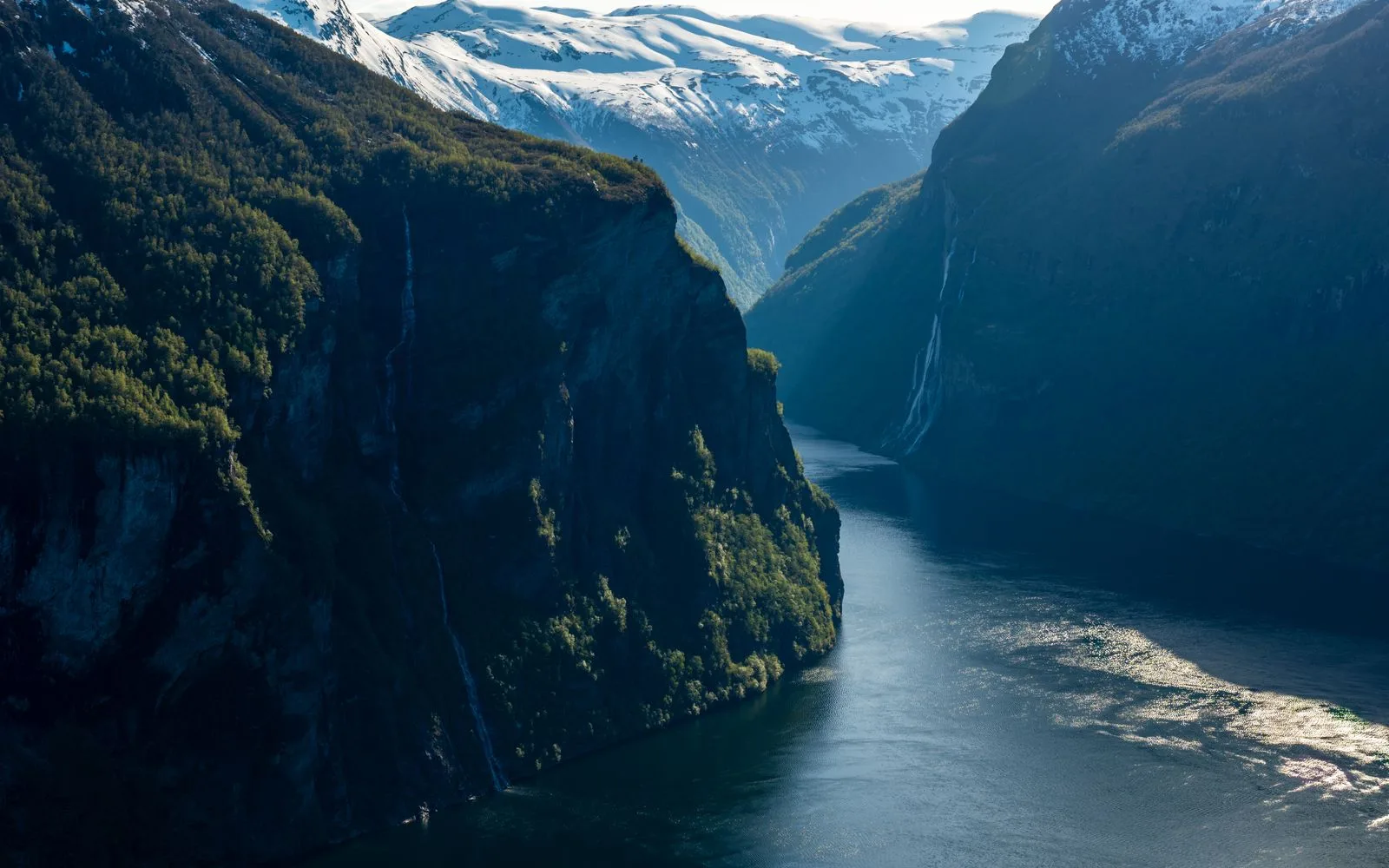 Snow-capped peaks over the blue water of Geirangerfjord